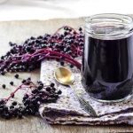 elderberry syrup in open jar with spoon