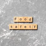 Food Safety spelled out in tiles with letters on each tile with a grey marble background