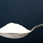 sugar on a spoon with a dark background