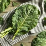 collard green leaves placed on a stiped kitchen cloth