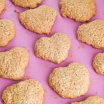 rows of heart shaped banana oat cookies on a pink background