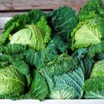 green cabbages in a wooden produce crate