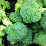 close up photo of a pile brightly colored green heads of broccoli