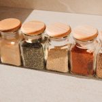 a row of dried spices in glass jars