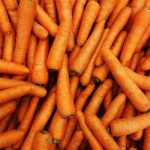 Aerial photo looking down onto a pile of brightly colored orange carrots