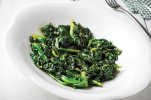 bowl of cooked spinach with lemon