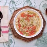 bowl of split pea soup on a table with utensils