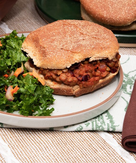 sloppy joe sandwich next to dark green coleslaw on a plate