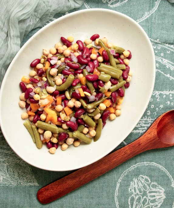 beans in a bowl next to a spoon on table